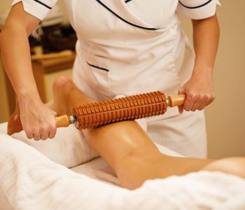 unrecognizable-therapist-performing-maderotherapy-woman-s-legs-during-massage-treatment-spa-min